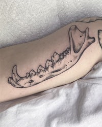 a tattoo of a skull with teeth on it