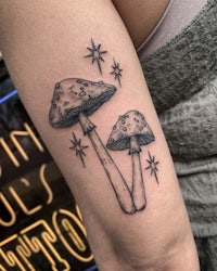 a tattoo of two mushrooms with stars on it