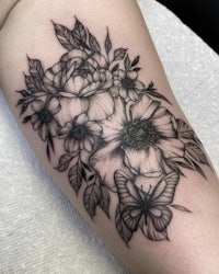 a black and white tattoo of flowers and butterflies